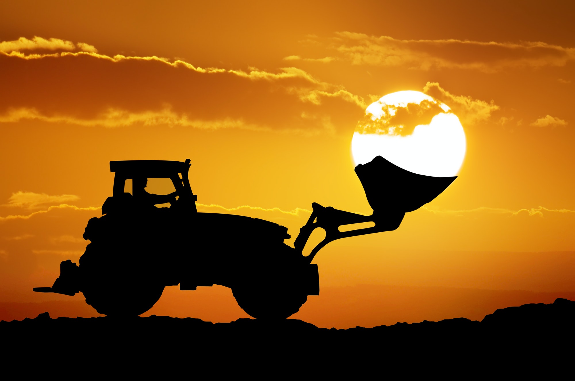 Tractor and sun into shovel bucket.